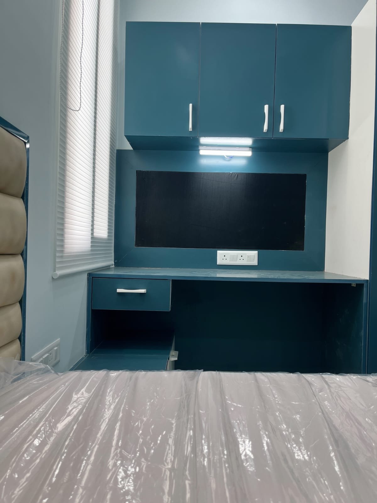 Teal fitted study unit with overhead cabinets