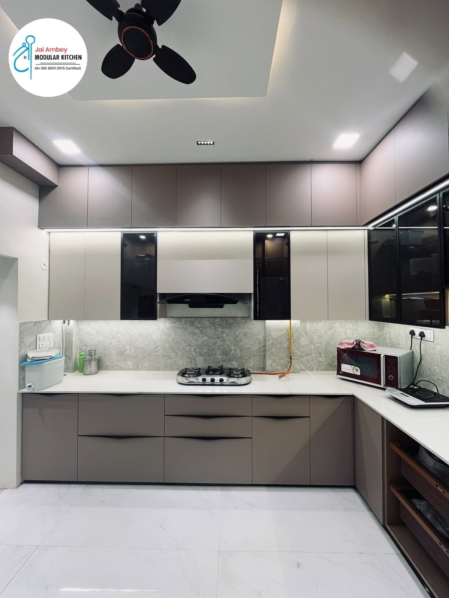 Modular kitchen in Indore with taupe gloss shutters and white quartz counter by Jai Ambey Modular Kitchen